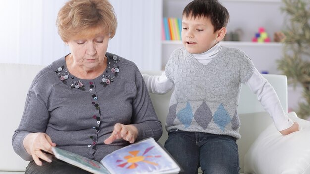 Retrato de avó e neto lendo um livro no berçário