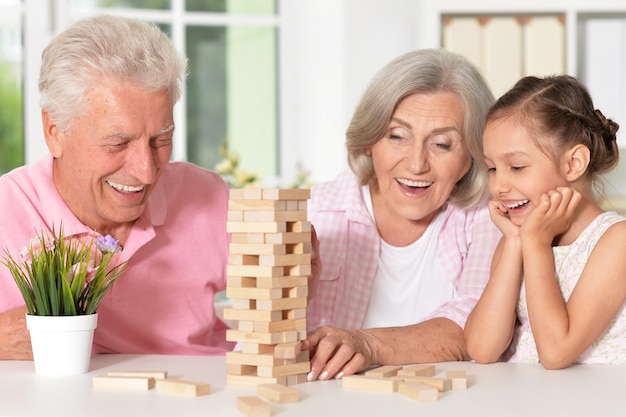 Retrato de avós felizes com a neta brincando juntos