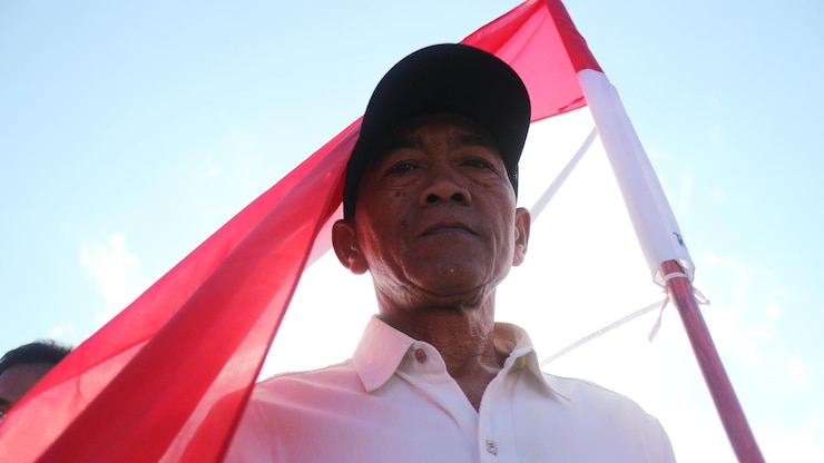 Foto retrato de baixo ângulo de um homem de pé contra a bandeira