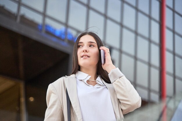 Retrato de baixo de uma empresária falando em um telefone celular