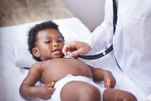 Foto retrato de bebê e pediatra com estetoscópio para consulta de batimento cardíaco ou infecção pulmonar, escuta ou exame de saúde, menino e rosto em leito de hospital ou bem-estar na clínica do quênia ou doente