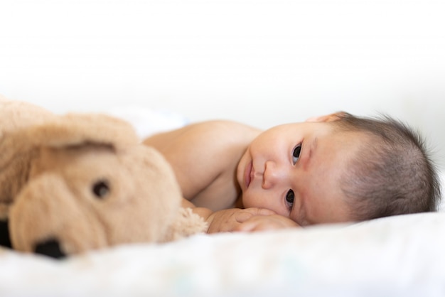 Retrato de bebê feliz relaxante na cama