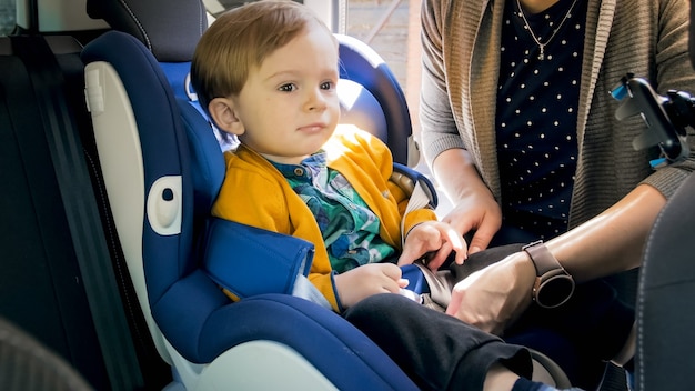 Retrato de bebê fofo sentado na cadeira de segurança do carro.