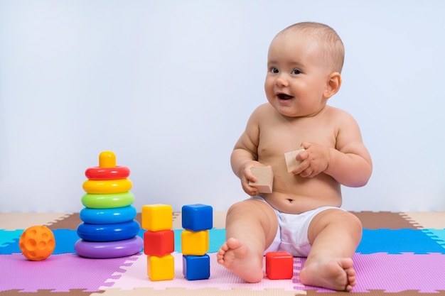 Retrato de bebê rindo feliz 8-12 meses de idade na sala de jogos em fundo branco