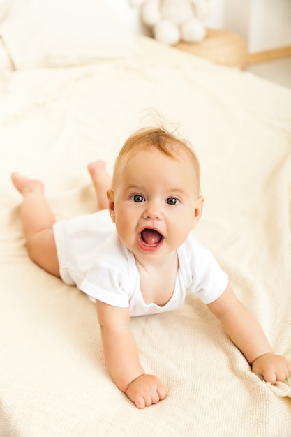 Retrato de bebê sorriso feliz relaxante na cama