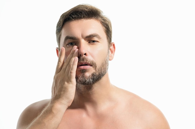 Retrato de beleza de um homem bonito com creme hidratante no rosto isolado skincar de fundo