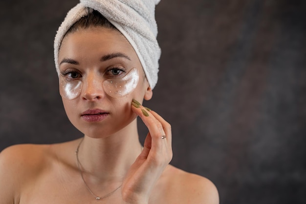 Retrato de beleza mulher jovem fazendo procedimentos anti-envelhecimento com manchas nos olhos para pele perfeita isolada no conceito de cuidados com a pele escura