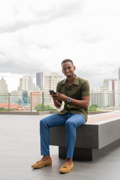 Retrato de belo jovem negro ao ar livre na cidade