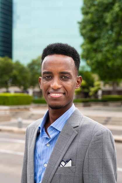 Retrato de belo jovem negro ao ar livre na cidade