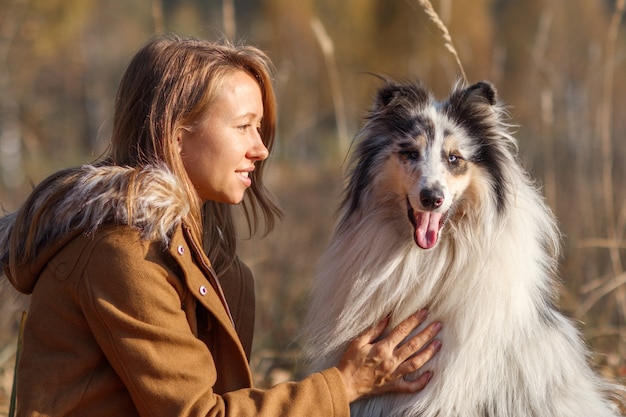 Retrato de Blue Merle Rough Collie e uma garota em Autumn Park