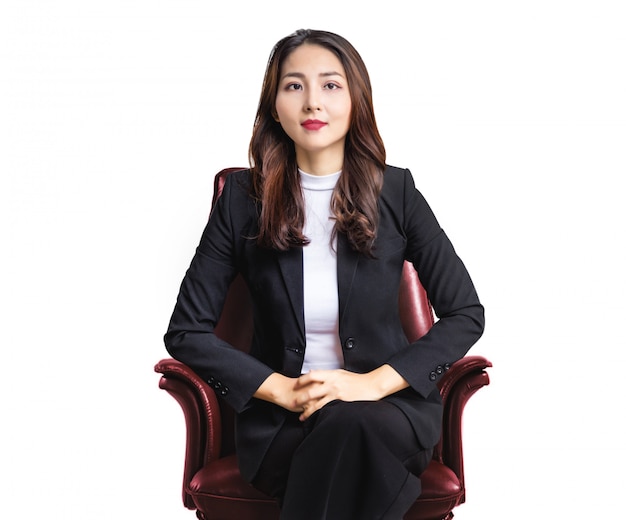 Retrato de boa atitude personalidade mulher de negócios asiática sentada na poltrona de couro vermelho na parede branca isolada