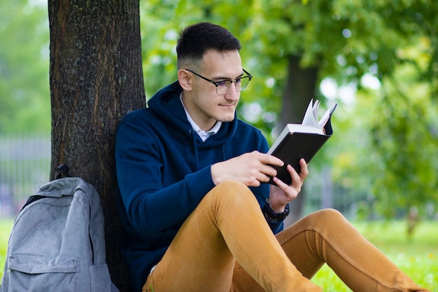 retrato de bonito estudante universitário inteligente ao ar livre em parque verde