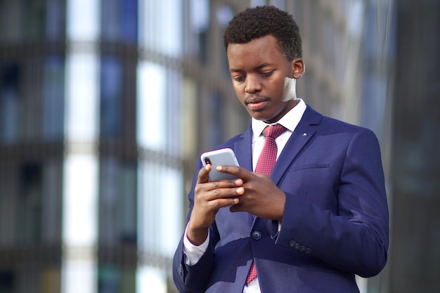 Retrato de bonito feliz negro jovem afro-americano empresário ao ar livre, escritório ao ar livre em copos