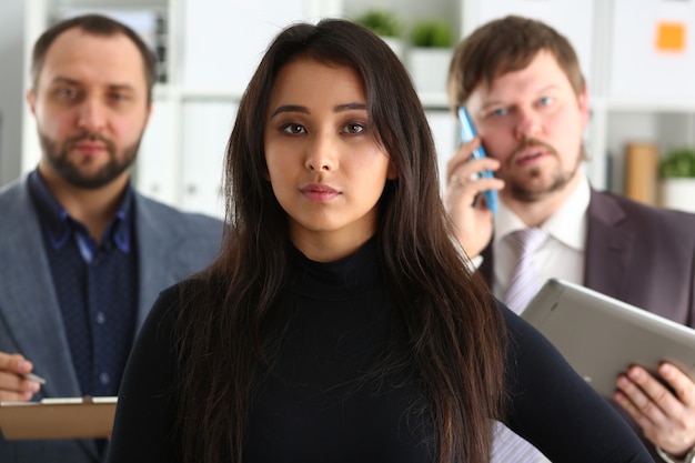 Retrato de businesslady e dois empresários no escritório