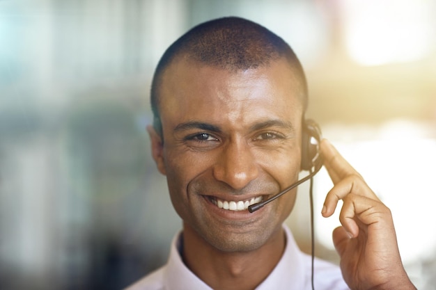 Retrato de call center e homem feliz em suporte de negócios de comunicação virtual e comércio eletrônico ajudando Face of IT consultor de agente ou sorriso de pessoa africana para atendimento ao cliente de telecomunicações ou aconselhamento ao cliente