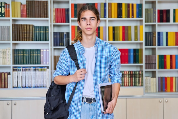 Retrato de cara adolescente estudante olhando para a câmera na biblioteca