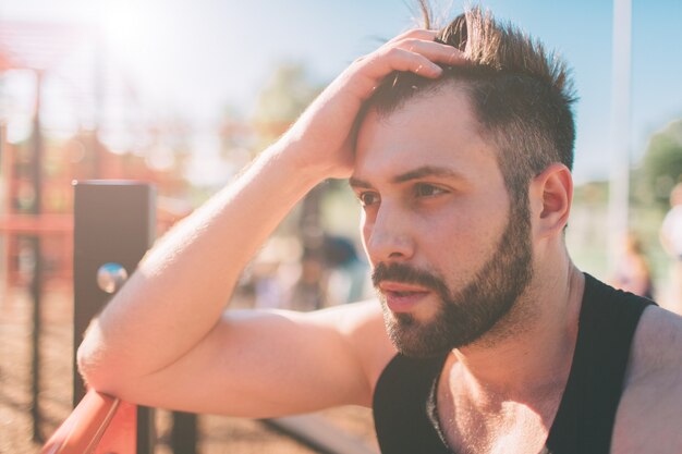 Retrato de cara de aptidão cansada em dia ensolarado. homem de esporte descansando depois de um treino duro.