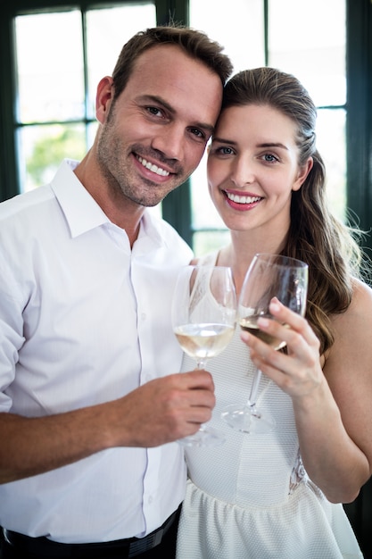 Retrato de casal brindando com taças de vinho