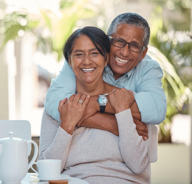 Retrato de casal de idosos abraçando e se unindo feliz e aproveitando a pausa para o chá em casa juntos amor de aposentadoria e sorrindo homem e mulher abraçando e descansando em sua casa diversão e carinho afeto