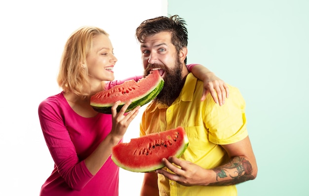 Retrato de casal feliz desfrutando de melancia alegre casal segurando fatias de cara engraçada de melancia