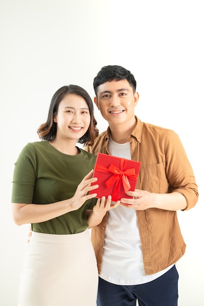 Retrato de casal feliz em pé casual, segurando uma caixa com um presente