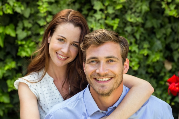 Retrato de casal feliz no jardim da frente