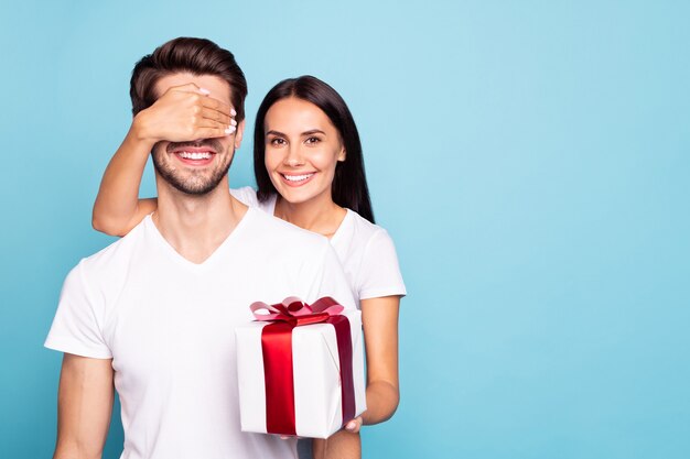 Retrato de casal garota fechando os olhos de rapazes preparando um presente