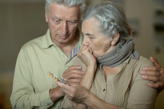 Retrato de casal idoso doente com comprimidos