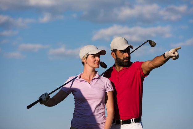 retrato de casal jovem feliz no campo de golfe