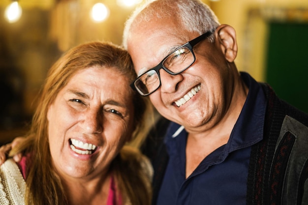 Retrato de casal latino sênior tendo momentos de ternura juntos - foco no rosto do homem