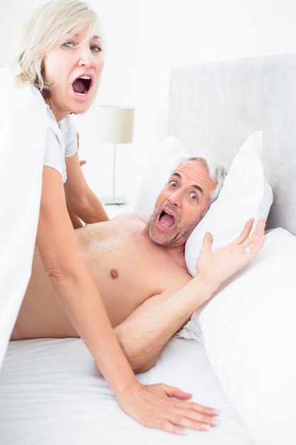 Foto retrato de casal maduro gritando na cama