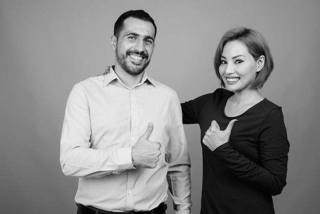 Retrato de casal multiétnico juntos e apaixonados em cinza em preto e branco