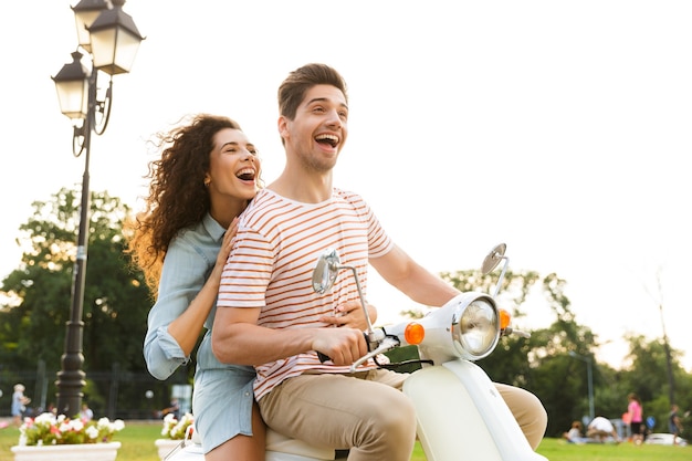 Retrato de casal romântico, andando de moto juntos pelas ruas da cidade