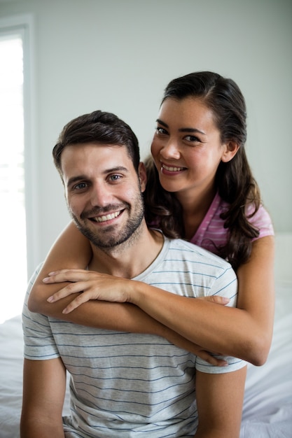 Retrato de casal se abraçando no quarto da casa