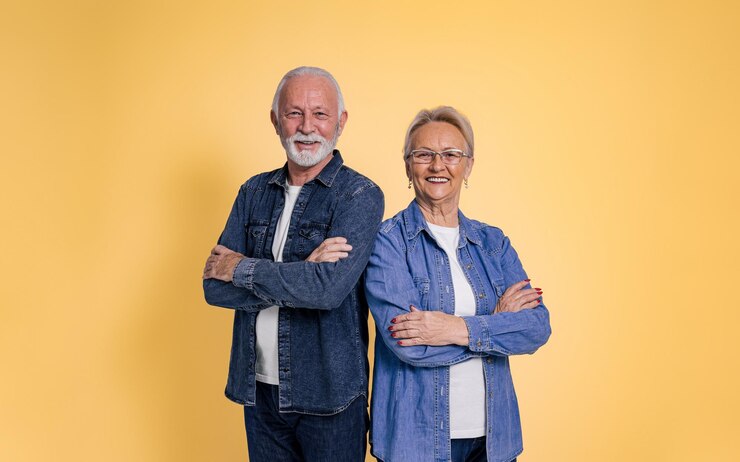 Foto retrato de casal sênior feliz e confiante vestindo camisas jeans com braços cruzados