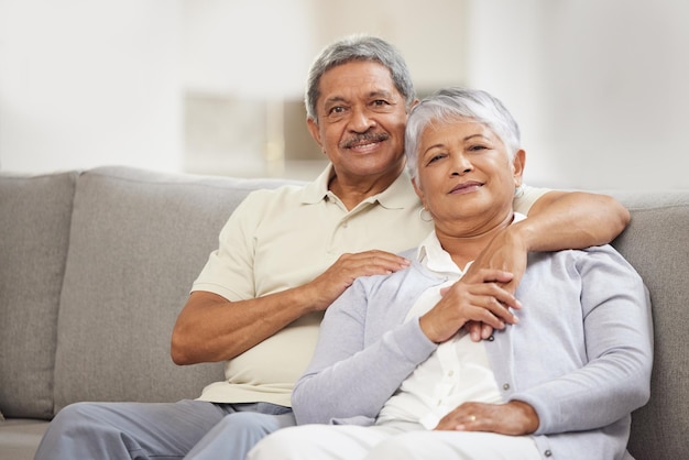 Retrato de casal sênior relaxa com amor em um sofá da sala de estar em casa sorriso feliz e desfruta de paz, liberdade e estilo de vida calmo Romântico idoso e mulher vivendo a vida de aposentadoria juntos se unindo