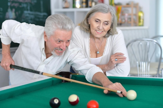 Retrato de casal sênior sorridente jogando bilhar juntos