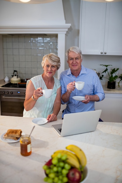 Retrato de casal sênior tomando chá na cozinha