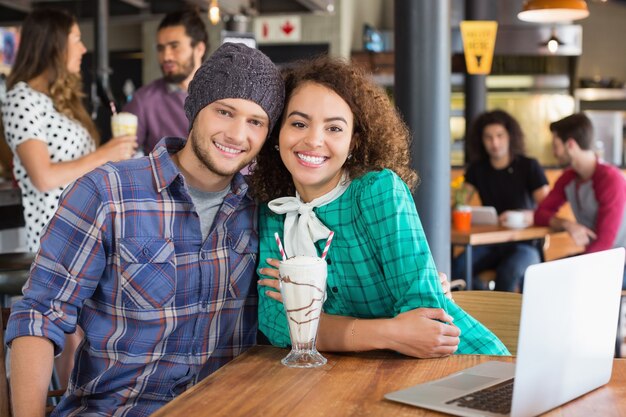 Retrato de casal sorridente sentado em um restaurante