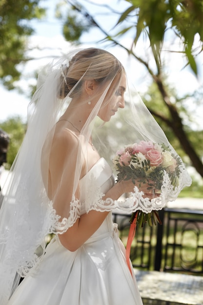 Retrato de casamento de uma noiva mulher sob um véu branco.