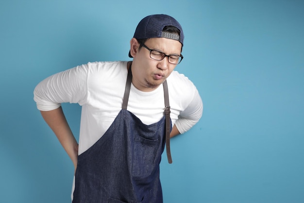 Retrato de chef ou garçom asiático masculino sofre de expressão cansada de dor lombar