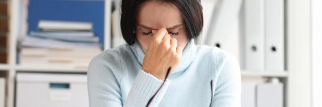 Retrato de chefe feminina cansada e sobrecarregada no local de trabalho, mulher estressante e exausta, toca na cabeça