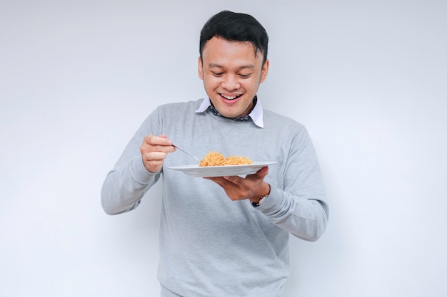 Retrato de Choque e Uau Jovem asiático gosta de macarrão Comendo o conceito de almoço