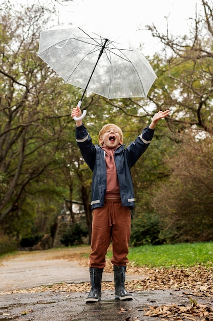 Retrato de chuva de um menino jovem e bonito