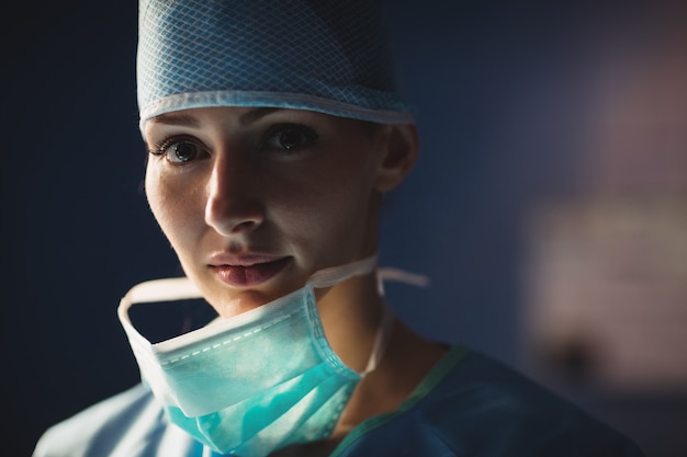 Retrato de cirurgiã sorridente na sala de operação