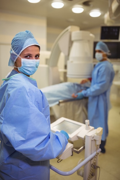 Foto retrato de cirurgiã usando a máquina no teatro de operações