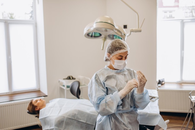 Retrato de cirurgiã usando esfoliação e óculos de proteção no centro cirúrgico do hospital