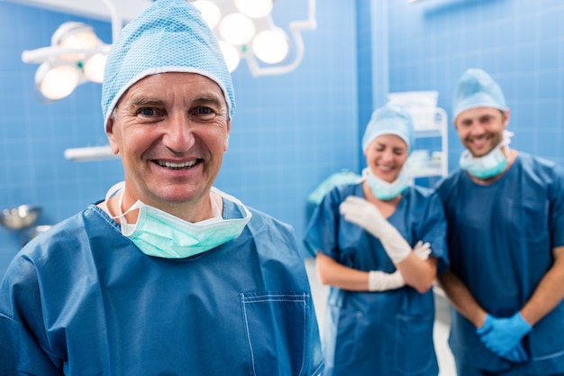 Retrato de cirurgião e enfermeiras sorrindo na sala de operação