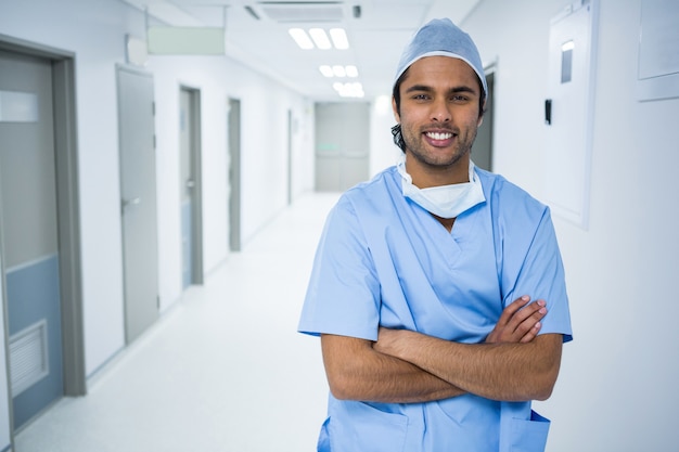 Retrato de cirurgião sorridente em pé no corredor