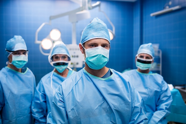 Retrato de cirurgiões em pé na sala de operação